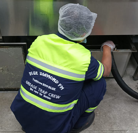 Man cleaning Grease Trap